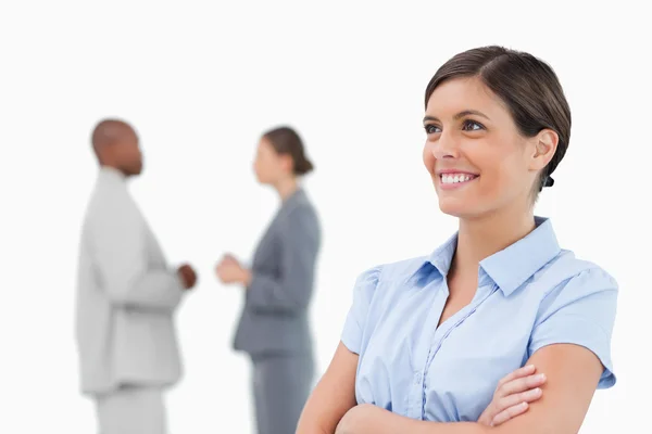 Smiling businesswoman with crossed arms and colleagues behind he — Stock Photo, Image