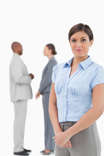 Saleswoman with talking associates behind her — Stock Photo, Image