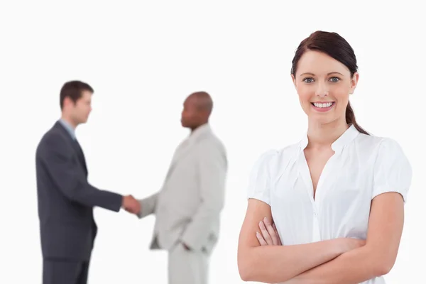 Businesswoman with arms folded and hand shaking trading partners — Stock Photo, Image