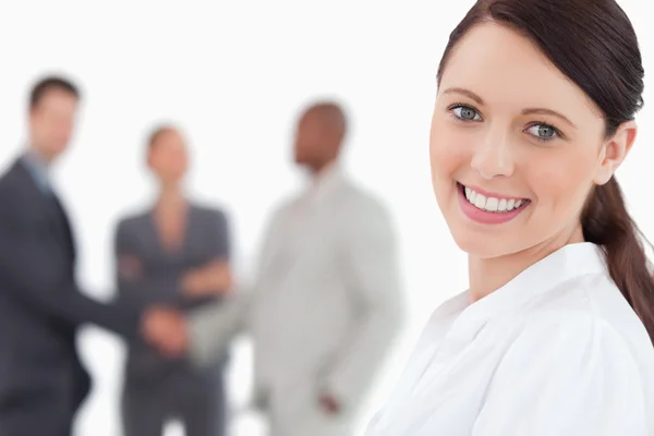 Smiling businesswoman with three associates behind her — Stock Photo, Image