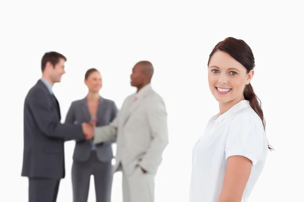 Smiling saleswoman with three colleagues behind her — Stock Photo, Image