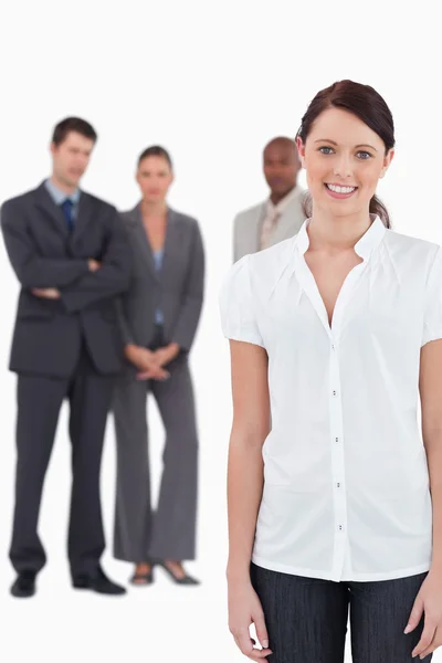 Smiling businesswoman with three co-workers behind her — Stock Photo, Image