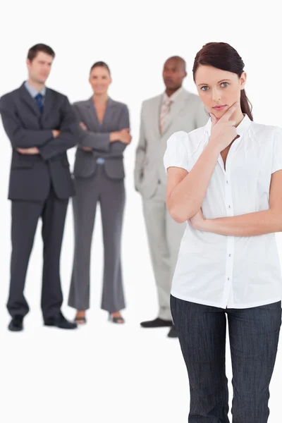 Thinking businesswoman with three colleagues behind her — Stock Photo, Image