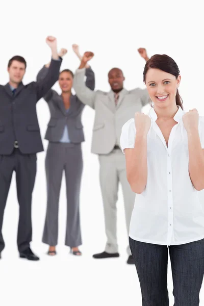 Successful businesswoman with cheering colleagues behind her — Stock Photo, Image
