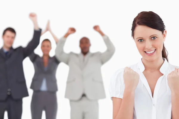 Victorious businesswoman with cheering team behind her — Stock Photo, Image