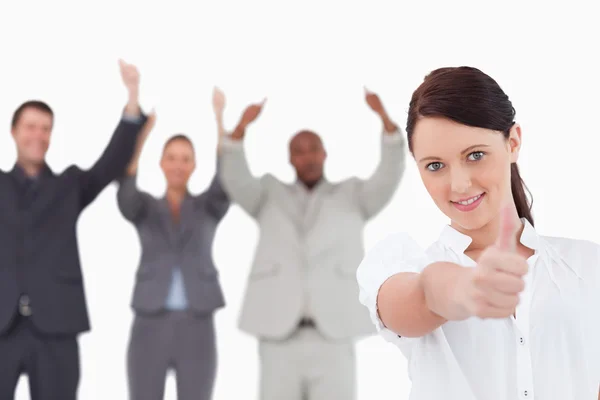 Zakenvrouw met gejuich collega's achter haar geven duim u — Stockfoto