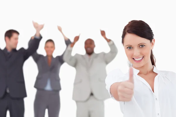 Saleswoman with cheering colleagues giving thumb up — Stock Photo, Image