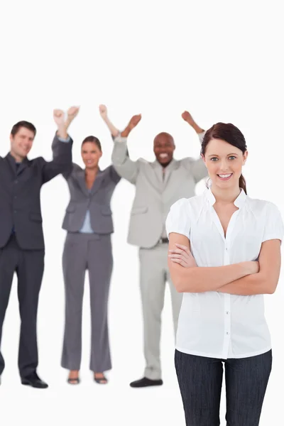 Smiling businesswoman with cheering co-workers behind her — Stock Photo, Image