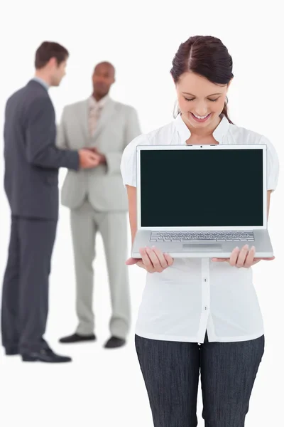 Бізнес-леді показує блокнот з колегами за нею — стокове фото