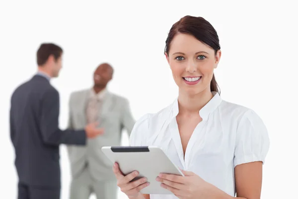 Businesswoman with tablet and colleagues behind her — Stock Photo, Image