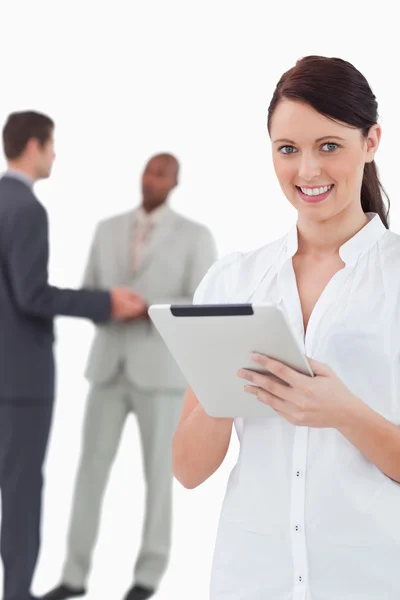 Businesswoman with tablet and associates behind her — Stock Photo, Image