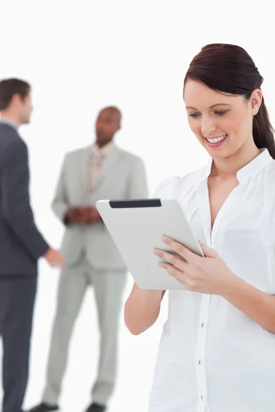 Saleswoman with tablet and associates behind her — Stock Photo, Image