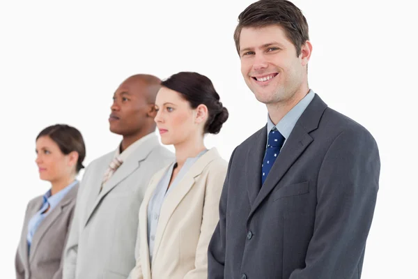 Uomo d'affari sorridente in piedi accanto alla sua squadra — Foto Stock