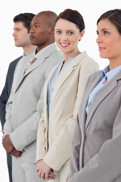 Smiling businesswoman standing between her associates — Stock Photo, Image