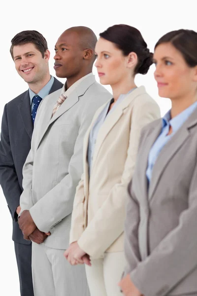 Smiling salesman standing next to his associates — Stock Photo, Image