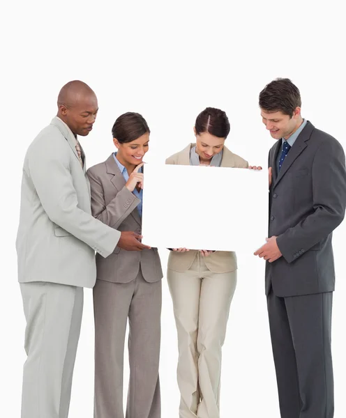 Salesteam holding blank sign together — Stock Photo, Image