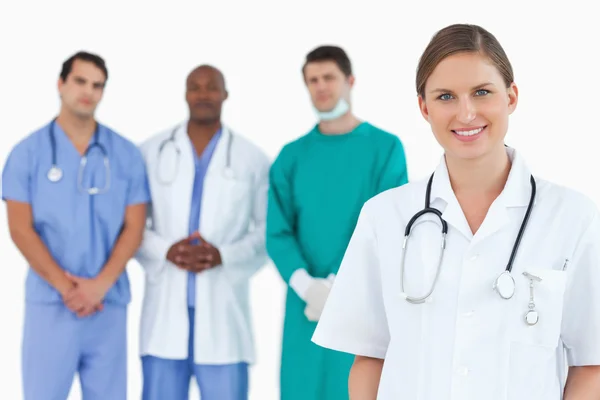 Female doctor with colleagues behind her — Stock Photo, Image
