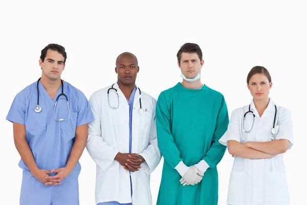 Squadra medica dall'aspetto serio in piedi insieme — Foto Stock