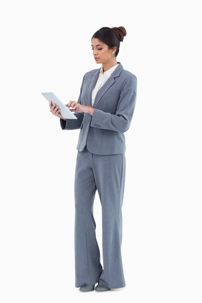 Geschäftsfrau blickt auf Tablet vor weißem Hintergrund — Stockfoto