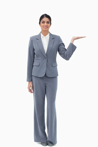 Donna d'affari sorridente che presenta con palmo in su — Foto Stock