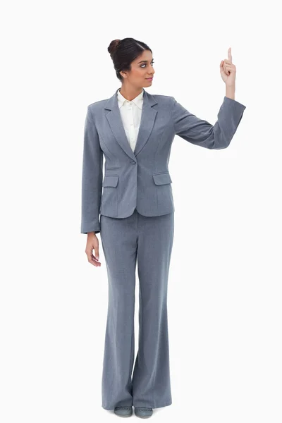 Businesswoman pointing upwards against a white background — Stock Photo, Image