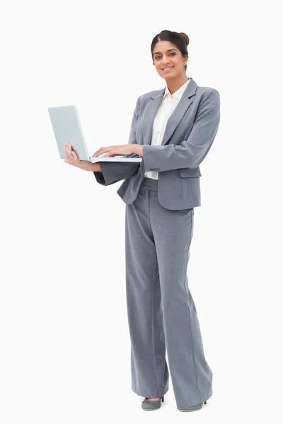 Улыбающаяся деловая женщина с ноутбука, стоя — стоковое фото