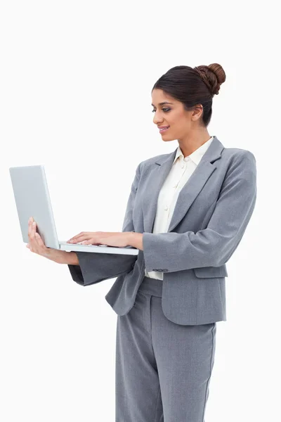 微笑女商人使用她站立时的笔记本电脑 — 图库照片