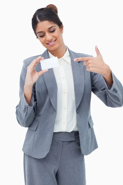 Χαμογελώντας tradeswoman δείχνει σε κενό επαγγελματική κάρτα — Φωτογραφία Αρχείου