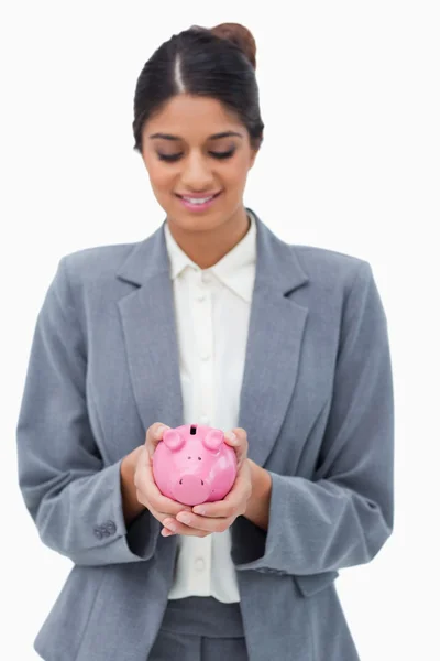 Sorrindo funcionário do banco olhando para o banco porquinho em suas mãos — Fotografia de Stock