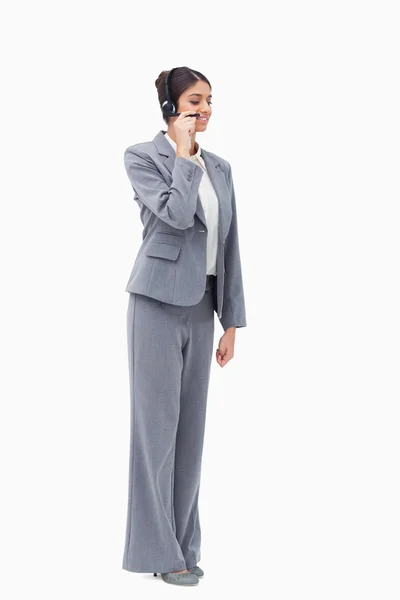 Agente de call center permanente com fone de ouvido — Fotografia de Stock