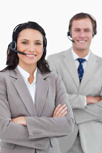 stock image Smiling call center agents with headsets and arms folded