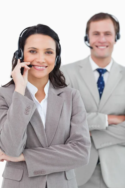 Call center agenten met headsets op glimlachend en armen gevouwen — Stockfoto