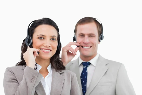 Sonriente equipo de centro de llamadas con sus auriculares —  Fotos de Stock