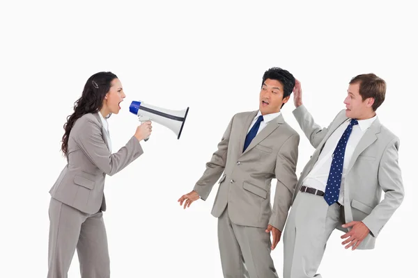 Businesswoman with megaphone yelling at colleagues — Stock Photo, Image