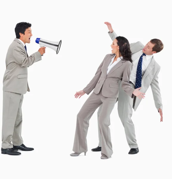 Businessman with megaphone shouting at colleagues — Stock Photo, Image