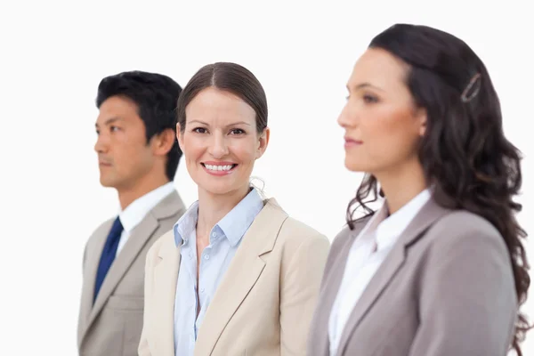 Smiling businesswoman between her colleagues — Stock Photo, Image