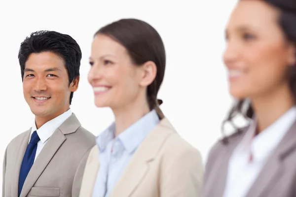 Smiling salesman standing next to smiling colleagues — Stock Photo, Image