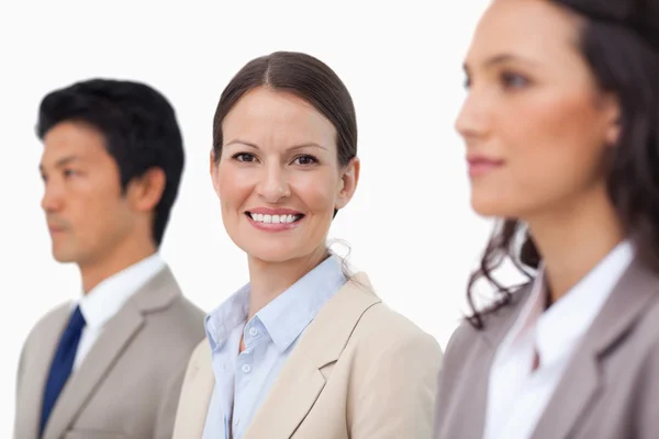 Smiling saleswoman between her colleagues — Stock Photo, Image