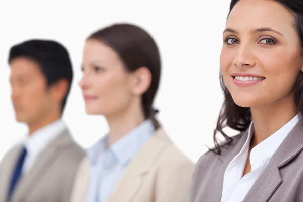 Усміхнена бізнес-леді стоїть поруч з колегами — стокове фото