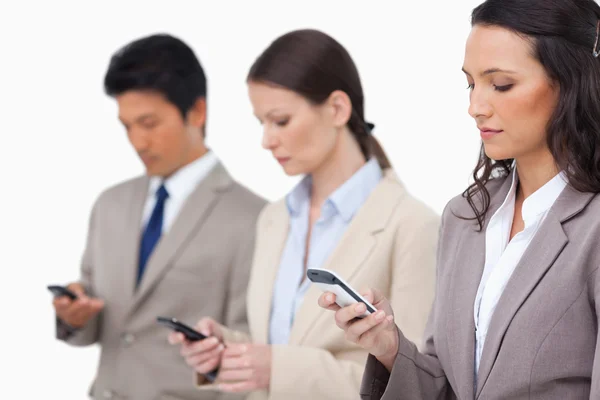 Businessteam titta på deras mobiltelefoner — Stockfoto