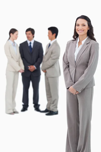 Smiling saleswoman with her team behind her — Stock Photo, Image
