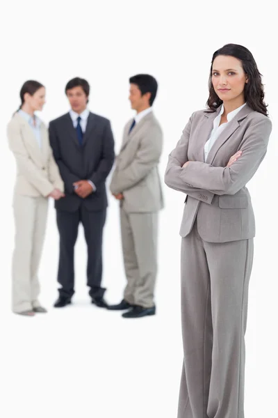 Serious saleswoman with arms crossed and team behind her — Stock Photo, Image