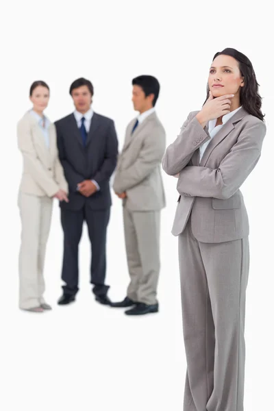 Thoughtful saleswoman with team behind her — Stock Photo, Image