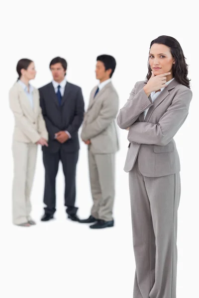 Thinking saleswoman with team behind her — Stock Photo, Image