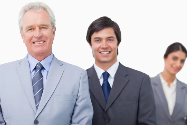 Smiling mature salesman with his employees — Stock Photo, Image