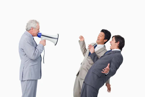 Старший бизнесмен с мегафоном кричит на своих сотрудников — стоковое фото