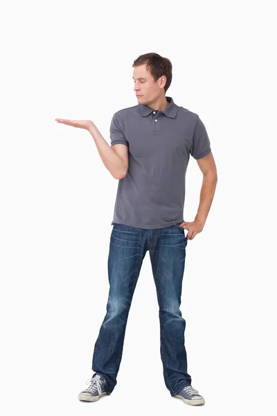 Junger Mann präsentiert mit erhobener Handfläche — Stockfoto