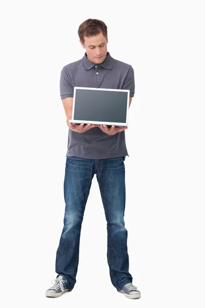 Ung man visar skärmen på sin laptop — Stockfoto