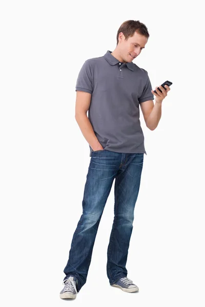 Genç adam onun cep telefonundan kısa mesaj yazarak — Stok fotoğraf