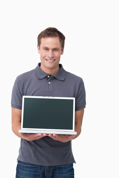 Gülümseyen genç adam onun Notebook ekran gösteriliyor — Stok fotoğraf